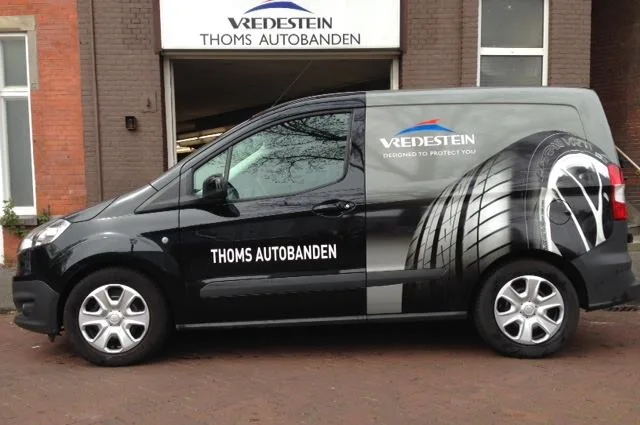 Bedrijfswagen van Thoms Autobanden voor het pand in Den Haag